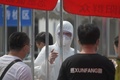 中国・北京の新型コロナウイルス検査所で、防護服を着用して働く職員（2020年6月28日撮影）。(c)GREG BAKER / AFP