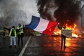 フランス・パリで、燃料税値上げの抗議活動中に国旗を掲げる人々（2018年12月1日撮影）。(c)Abdulmonam EASSA / AFP