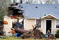 米ミシシッピ（Mississippi）州ハッティズバーグ（Hattiesburg）市で竜巻に遭い損壊した家と放心状態で座り込む住民（2013年2月11日撮影）。(c)AFP/Getty Images/Sean Gardner