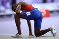 パリ五輪、陸上男子200メートル決勝。レース後に膝をつく米国のノア・ライルズ（2024年8月8日撮影）。(c)Anne-Christine POUJOULAT / AFP