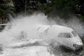 中米ホンジュラスのトンコンティン空港で、滑走路を外れて大通りに突っ込み大破した航空機の消火作業の様子（2018年5月22日撮影）。(c)AFP PHOTO / Orlando SIERRA