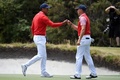 米国選抜と世界選抜による男子ゴルフの対抗戦、第13回プレジデンツ・カップ初日。ジャスティン・トーマス（右）とグータッチする米国選抜のタイガー・ウッズ（2019年12月12日撮影）。(c)William WEST / AFP