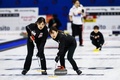 女子カーリング、北京冬季五輪世界最終予選プレーオフ、日本対韓国。スイープする吉田知那美（左）と鈴木夕湖（2021年12月17日撮影）。(c)Vincent Jannink / ANP / AFP
