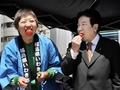 都内即売会で福島県いわき市産のイチゴを食べる枝野幸男（Yukio Edano）官房長官（右）と、トマトを食べるお笑いコンビ南海キャンディーズのしずちゃんこと山崎静代（Shizuyo Yamasaki）さん（左、2011年4月12日撮影）。(c)AFP/Yoshikazu TSUNO