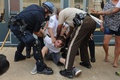 米ミズーリ（Missouri）州セントルイス（St. Louis）郡ファーガソン（Ferguson）で、マイケル・ブラウン（Michael Brown）さん（18）が警官に射殺された事件への抗議デモで、警官に身柄を拘束される参加者（2014年8月11日撮影）。(c)AFP/Getty Images/Michael B. Thomas