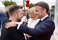 Dデー80年の記念式典が開催された仏ノルマンディーで、握手を交わすウクライナのウォロディミル・ゼレンスキー大統領（左）とフランスのエマニュエル・マクロン大統領（2024年6月6日撮影）。(c)Ludovic MARIN / POOL / AFP