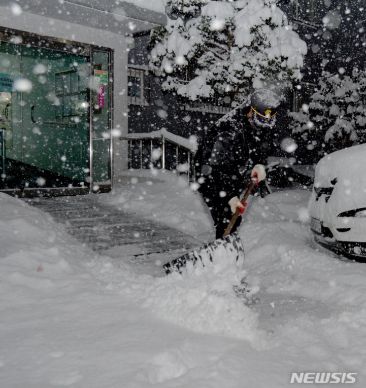 昨年12月23日午前、光州のあるマンションで雪かきをする警備員(c)NEWSIS