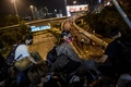 香港理工大学の構内から脱出するため、歩道橋から幹線道路へとロープで下りるデモ参加者（2019年11月18日撮影）。(c)AFP/Ye Aung Thu