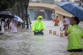 中国・河南省鄭州市で、冠水した道路で自転車をこぐ人（2021年7月20日撮影）。(c)STR / AFP