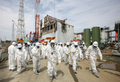 東京電力（TEPCO）は26日、福島第1原子力発電所の敷地内を報道陣に公開した。写真は第1原発4号機を取材する報道陣と東電従業員（2012年5月26日撮影）。(c)AFP/POOL/Tomohiro Ohsumi