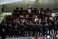 香港立法会（議会）で、中国国歌への侮辱行為に罰則を科す国歌条例案の審議中に、警備担当者らともみ合いになる民主派議員ら（2020年6月4日撮影）。(c)ISAAC LAWRENCE / AFP
