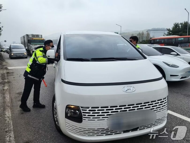 バス専用車線を走行した車両を取り締まる警察官(c)news1