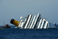 イタリア中部ジリオ（Giglio）島付近の浅瀬で1月に座礁、32人が死亡・行方不明になり、船体の半分が沈没したまま放置されていたクルーズ船「コスタ・コンコルディア（Costa Concordia）号」の引き揚げ作業が今週開始された。

写真はジリオ島の岸から見える「コスタ・コンコルディア（Costa Concordia）号」（2012年6月25日撮影）。(c)AFP/VINCENZO PINTO