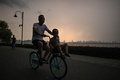 中国・湖北省武漢の東湖そばで、自転車に乗る男性（2020年8月5日撮影）。(c)Hector RETAMAL / AFP