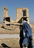 2008年2月1日、アフガニスタンの首都カブール（Kabul）で、内戦で破壊された建物の前を通り過ぎるブルカ姿の女性ら。(c)AFP/SHAH Marai