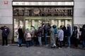 ロシア国営銀行ズベルバンクのチェコ・プラハ支店で、預金引き出しと口座解約のため並ぶ人（2022年2月25日撮影）。(c)Michal Cizek / AFP