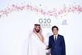 大阪で開催中の20か国・地域（G20）首脳会議の歓迎行事で、サウジアラビアのムハンマド・ビン・サルマン皇太子（左）を迎える安倍晋三首相（右、2019年6月28日撮影）。(c)Brendan Smialowski / AFP