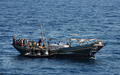 アフリカ・ソマリア沖のアデン湾（Gulf of Aden）で、海賊船に乗り込み掃討作戦を行うインド海軍と、手を上げて降参する海賊（2008年12月13日撮影）。(c)AFP/INDIAN NAVY