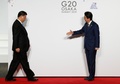 大阪で開催中の20か国・地域（G20）首脳会議の歓迎行事で、中国の習近平国家主席（左）を迎える安倍晋三首相（右、2019年6月28日撮影）。(c)KIM KYUNG-HOON / POOL / AFP