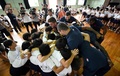 熊本市内の小学校を訪れ、児童たちとスクラムを組むフランスの選手（2019年9月26日撮影）。(c)FRANCK FIFE / AFP