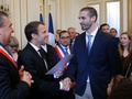仏中部オルレアンで、フランスの市民権を得た男性と握手をするエマニュエル・マクロン大統領（左、2017年7月27日撮影）。(c)AFP/Michel Euler