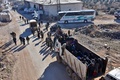 シリア北部アレッポ近郊の村で、戦闘を逃れ、政府軍側部隊が管理する検問所にトラックの荷台に乗って到着した住民たち（2016年12月9日撮影）。(c)AFP/George OURFALIAN