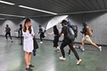 香港・九龍の鑽石山駅構内を破壊するデモ隊と携帯電話を持つ女性（2019年10月7日撮影）。(c)Philip FONG / AFP
