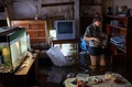 ロシア極東ハバロフスク（Khabarovsk）に近いクラスナヤレチタ（Krasnaya Rechka）村で、浸水した家の中で立っている女性（2013年8月22日撮影）。(c)AFP/IGOR CHURAKOV