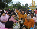 タイのプミポン・アドゥンヤデート（Bhumibol Adulyadej）国王は5日、84歳の誕生日を迎え、長期入院中のバンコク（Bangkok）の病院から一時王宮に戻り、祝賀式典に出席した。式典終了後、プミポン国王は病院に戻った。

写真は、タイ南部ナラティワート（Narathiwat）県で行われた国王誕生日の祝賀行事で行われた托鉢で、供物を受け取る仏僧（2011年12月5日撮影）。(c)AFP/MADAREE TOHLALA