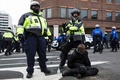 米首都ワシントンで、デモ参加者を拘束する警官隊（2017年1月20日撮影）。(c)AFP/ZACH GIBSON