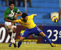 写真は、ボリビアの%%Carlos Tordoya%%と競りながらボールへ足を伸ばすブラジルのアレシャンドレ・パト（%%Alexandre Pato%%）。(c)AFP/Miguel ROJO