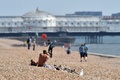 英イングランド南岸のブライトンにある海岸で、日光浴を楽しむ人々（2020年4月10日撮影）。(c)Glyn KIRK / AFP