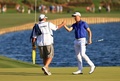 男子ゴルフ米国ツアー、プレーヤーズ選手権最終日。18番を終え、キャディーと共に優勝を喜ぶジャスティン・トーマス（右、2021年3月14日撮影）。(c)Mike Ehrmann/Getty Images/AFP