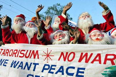 インドのイブ、平和訴えサンタクロースがデモ行進