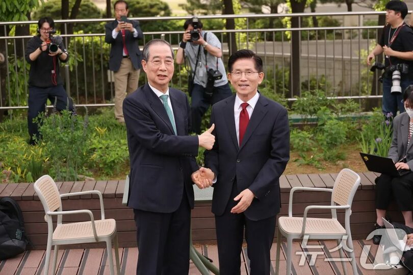 2025年5月8日午後、ソウル・汝矣島の国会内での会談で握手を交わすキム・ムンス氏（右）とハン・ドクス氏(c)news1