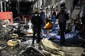 ロシアによるミサイル攻撃を受けたウクライナ・ハルキウ州の郵便施設で、現場に立つ警察官ら（2023年10月21日撮影）。(c)SERGEY BOBOK / AFP