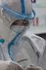 中国・武漢の紅十字会医院で、患者の体温を確認する防護服姿の医療関係者（2020年1月25日撮影）。(c)Hector RETAMAL / AFP