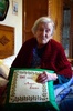 イタリア北部のベルバニアで、「116歳の誕生日おめでとう」と刺しゅうされた枕を抱え写真撮影に応じるエマ・モラノさん（2016年5月14日撮影）。(c)AFP/OLIVIER MORIN