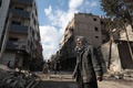 シリアの首都ダマスカス東郊にある反体制派が掌握するドゥーマ地区で、停戦が発効した初日、破壊された自宅のがれきを見つめる男性（2016年12月30日撮影）。(c)AFP/Abd Doumany