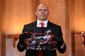 ボクシング、WBA・WBC・WBO世界ヘビー級タイトルマッチへ向けた会見で、自身がタイソン・フューリーにパンチを当てる写真を手にするオレクサンドル・ウシク（2024年10月23日撮影）。(c)JUSTIN TALLIS / AFP