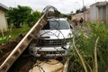 コートジボワールのアビジャンで、車の残骸のそばを歩く人々（2018年6月19日撮影）。(c)AFP PHOTO / Sia KAMBOU