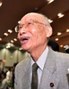 ノーベル医学生理学賞の受賞が決まったことを受けて東京都内の北里大学で開かれた記者会見の会場で、学生らからお祝いの言葉を掛けられて笑顔を見せる大村智・北里大特別栄誉教授（2015年10月5日撮影）。(c)AFP/Yoshikazu TSUNO