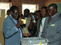 ジンバブエの首都ハラレ（Harare）の投票所で投票するロバート・ムガベ（Robert Mugabe）大統領（左、2013年7月31日撮影）。(c)AFP/ALEXANDER JOE