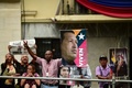 ベネズエラの国会前で、同国のニコラス・マドゥロ現大統領と故ウゴ・チャベス前大統領の写真を持つマドゥロ氏の支持者ら（2019年3月11日撮影）。(c)RONALDO SCHEMIDT / AFP