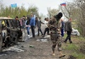 ウクライナ東部スラビャンスク（Slavyansk）近郊の検問所で起きた銃撃戦の現場を調べる武装した親ロシア派の男性（2014年4月20日撮影）。(c)AFP/GENYA SAVILOV