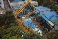 中国広東省東莞市の巨大クレーンが倒壊した建設現場で救助活動を行う救助隊（2016年4月13日撮影）。(c)AFP