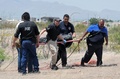メキシコ・チワワ州で、クリストファー・レイムンド・マルケスモラ君（6）の遺体を収容する警察官ら（2015年5月16日撮影）。(c)AFP/Daniel Acosta