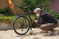 ギニアの首都コナクリで、自転車のギアを見つめるレイモンド・リーさん（2020年4月30日撮影）。(c)CELLOU BINANI / AFP