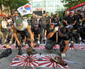 韓国・ソウル（Seoul）の日本大使館前で、竹島問題で日本に抗議し、日本の国鳥であるキジを殺しその血を日章旗に塗る退役軍人ら（2008年7月17日撮影）。(c)AFP/KIM JAE-HWAN