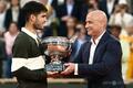 アルカラス全仏2連覇、シナーに大逆転勝ち 決勝史上最長の死闘 全仏オープンテニス、男子シングルス決勝。元選手のアンドレ・アガシ氏(右)からトロフィーを受け取るカルロス・アルカラス(2025年6月8日撮影)。(c)Thibaud MORITZ / AFP